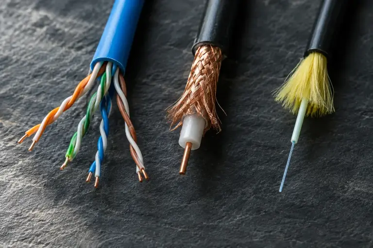 Ends of a twisted-pair, a coaxial and a fiber optic cable side by side on slate