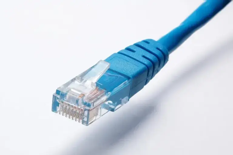 Close-up of a blue Ethernet patch cable ending in a clear RJ45 plug on a white background