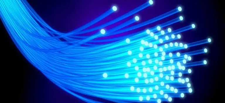 Bundle of glowing blue fiber optic strands with lit tips against a dark background