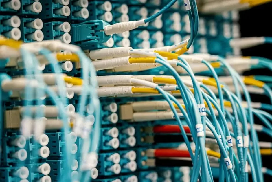 Aqua fiber patch cords with yellow-tagged connectors seated in a high-density patch panel