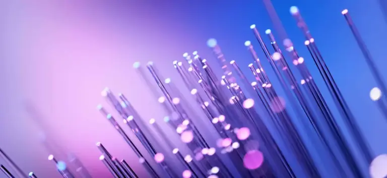 Close-up of fiber strand tips glowing pink and blue