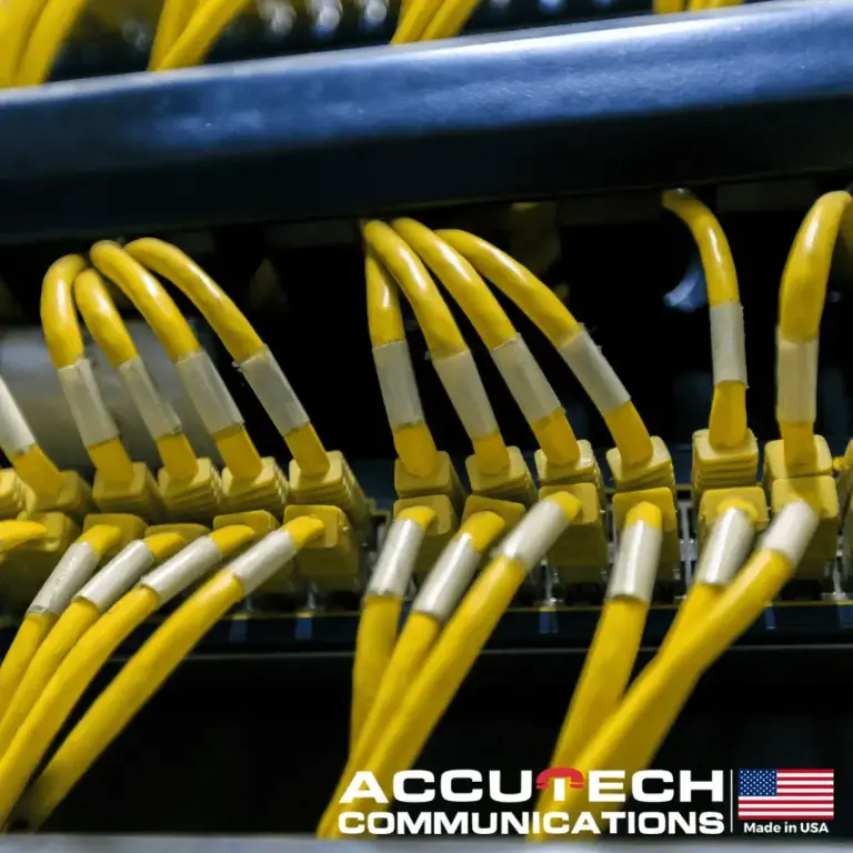 Yellow patch cables with white labels plugged into rows of network switch ports