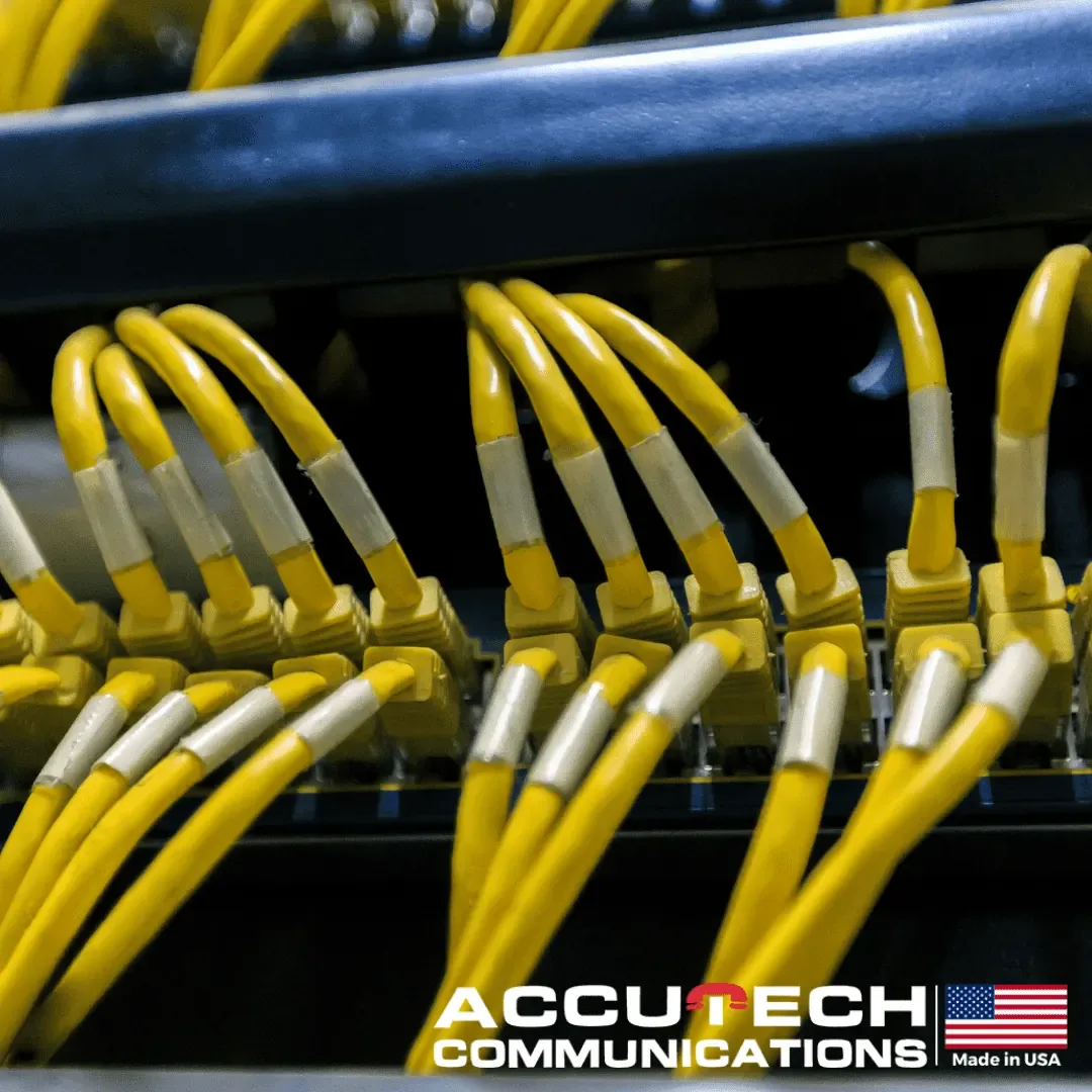 Yellow patch cables with white labels plugged into rows of network switch ports