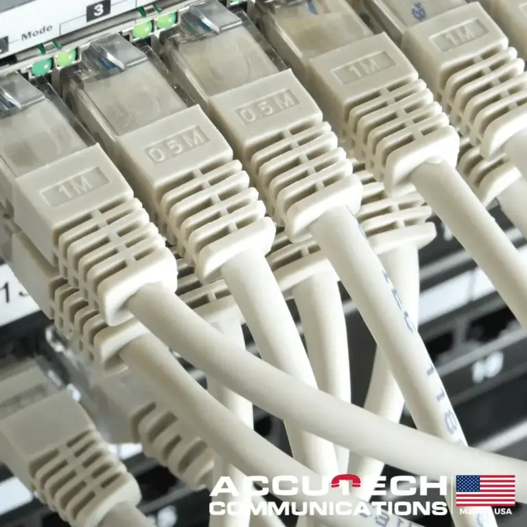 Beige patch cables with short length tags plugged into switch ports with green lights