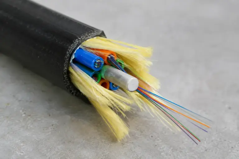 Cut fiber cable opened to show colored buffer tubes and yellow aramid yarn