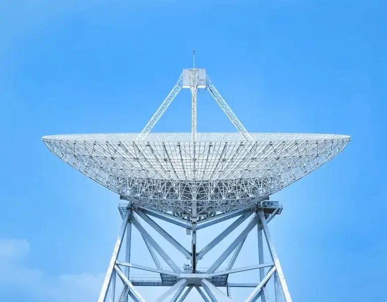 Large radio telescope dish on a white steel frame against a blue sky