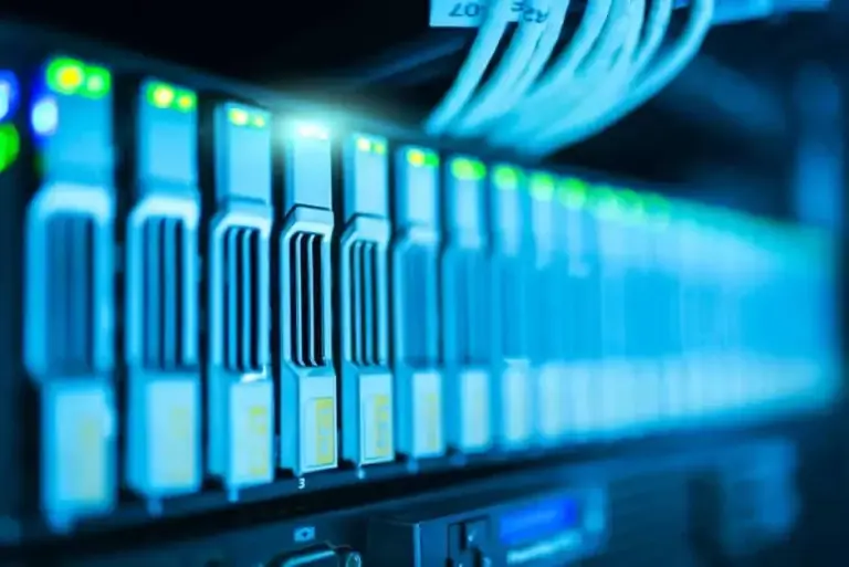Row of server drive bays with green status lights glowing in blue light