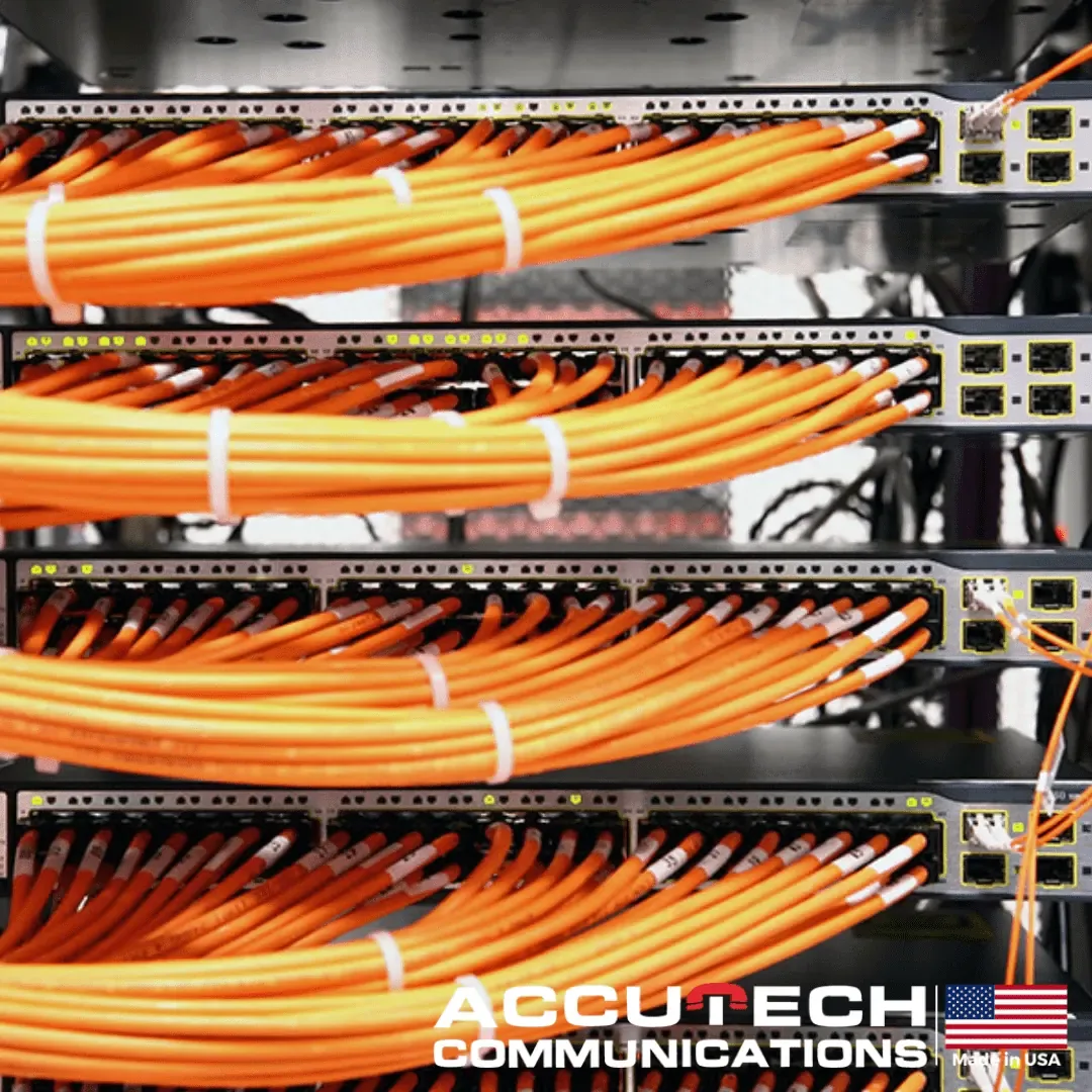 Orange patch cables bundled with white ties into stacked network switches